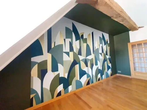 Salon moderne avec canapé turquoise, fauteuil rose poudré et papier peint tropical aux motifs de feuilles de monstera et palmier