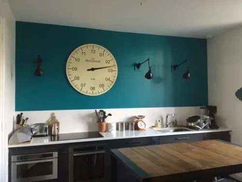 Intérieur moderne aux tons chauds avec fauteuil en bois et tissu beige, plaid gris, étagères murales illuminées intégrées